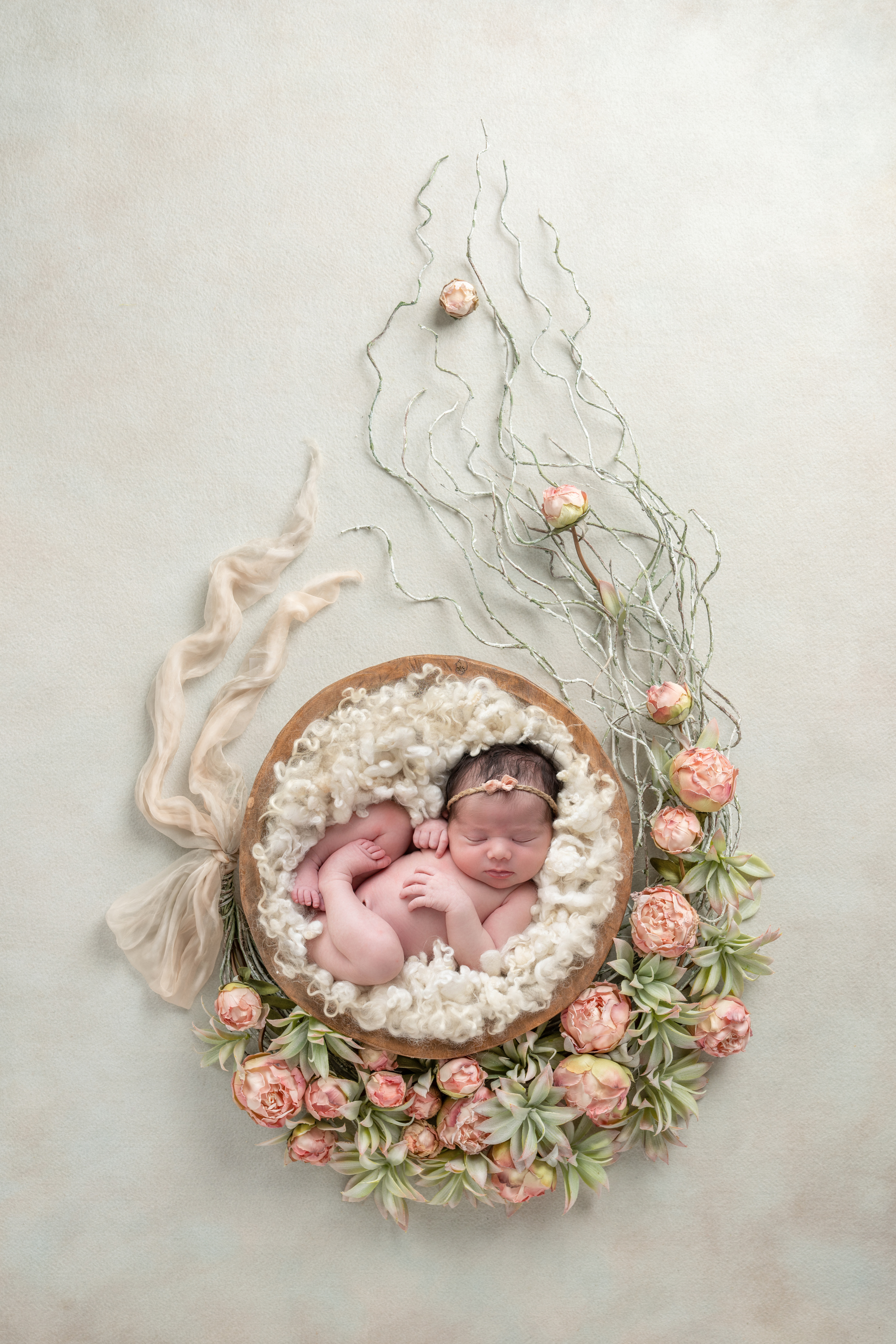 Newborn baby in a floral setting, an example of Ella Jaymes Photography's work.